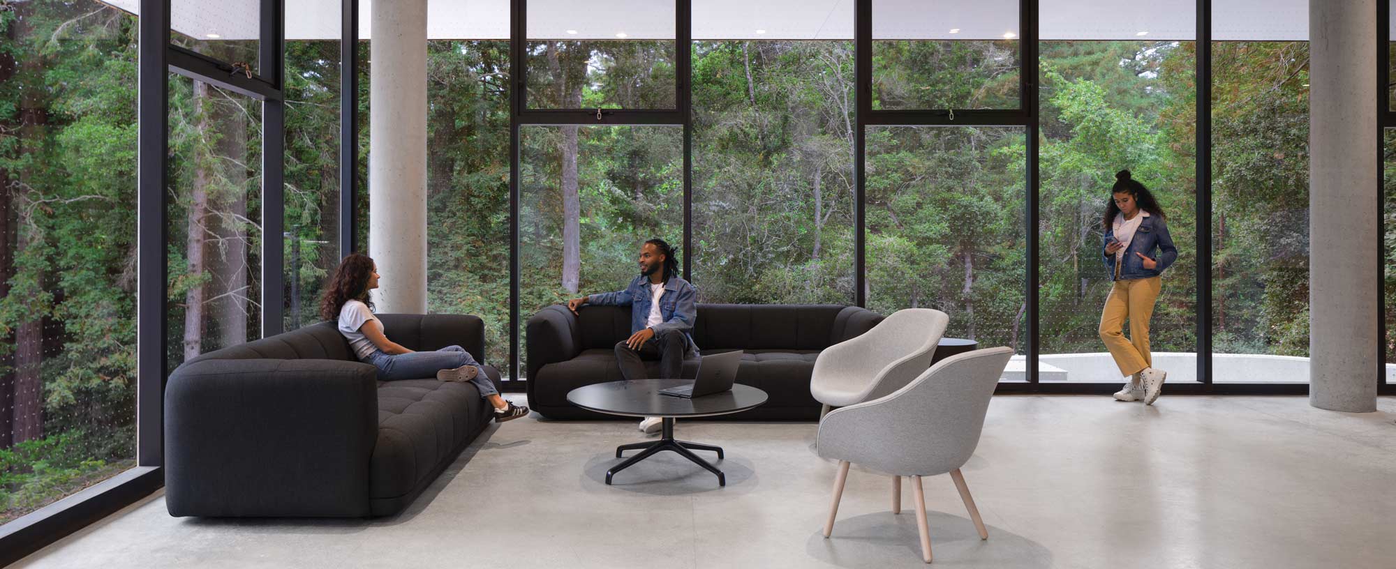 Students hang out in the common area with the view of the redwoods.