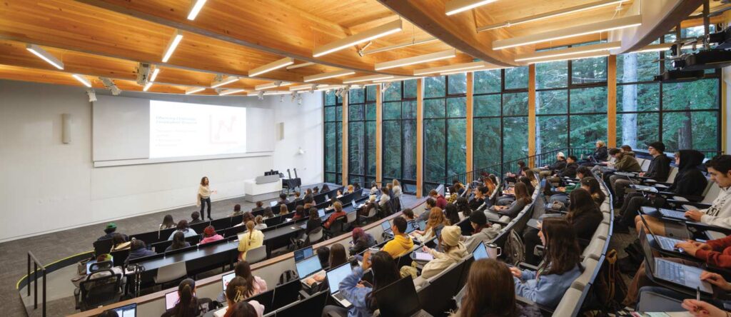 Students in UCSC classroom with windows view of the redwoods.